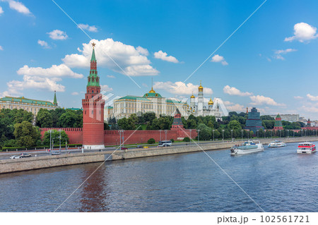 View of Kremlin with Vodovzvodnaya tower, Grand Kremlin Palace from repaired Bolshoy Kamenny Bridge in Moscow city on sunny summer day. Cruise ship sails on the Moscow river 102561721