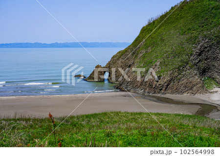 佐渡島を背景に越後七浦シーサイドライン角海浜(かくみはま)の海蝕洞 佐渡島を背景に越後七浦シーサイドライン角海浜(かくみはま)の海蝕洞 102564998