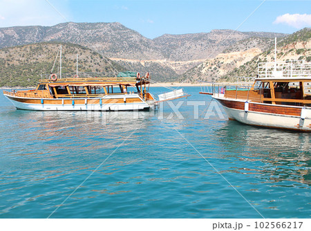 Tourist floating boat in blue sea in bright sunny summer. Side view. Landscape with yacht, mountains, blue water. Concept of sea, travel 102566217