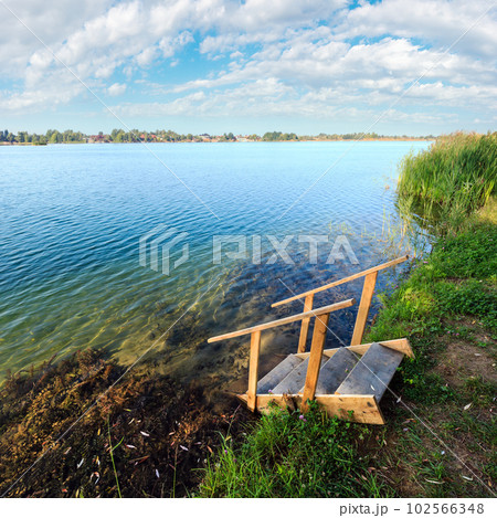 Summer lake calm beach with wood steeps to the water 102566348