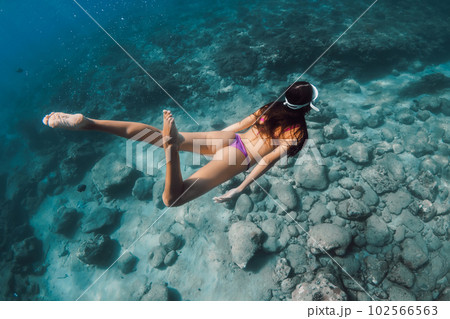 Woman with ideal body dive to the deep in tropical blue sea. Snorkeling with beauty lady in Hawaii 102566563