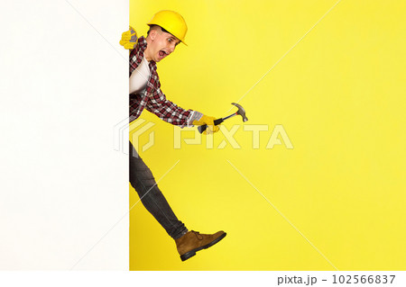 professional builder in work clothes in helmet holding hammer. 102566837