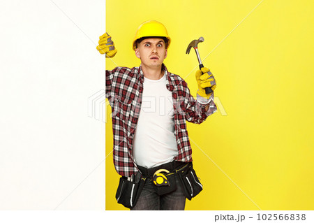 professional builder in work clothes in helmet holding hammer. 102566838