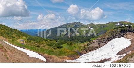 Summer mountain view with snow on mountainside (with observatory ruins on Chornogora Ridge, Ukraine). 102567016