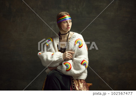 Portrait of attractive young girl in white cardigan and colorful hair accessories against dark green background. Lgbt community support 102567477