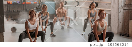 Group of people exercising with kettlebells at gym Group of people exercising with kettlebells at gym 102568014