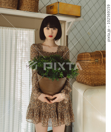 植物を抱えた若い女性 植物を抱えた若い女性 102569159
