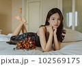 ベッドに寝そべる若い女性のファッションポートレート 102569175