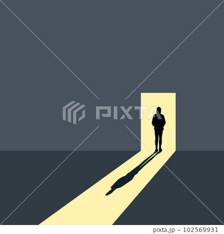 lonely girl stands in front of an open door on a gray wall 102569931