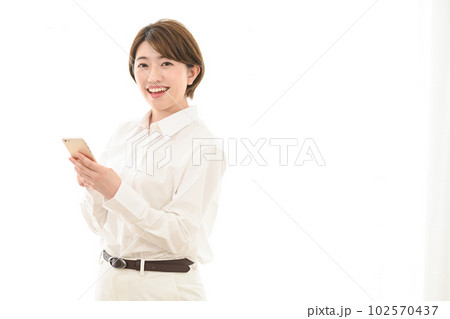 窓辺でスマホを見る女性 窓辺でスマホを見る女性 102570437