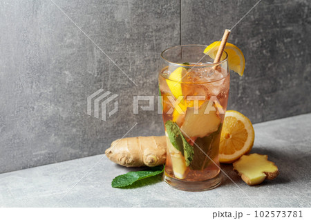 Iced tea with mint, ginger, and lemon on a grey background. 102573781