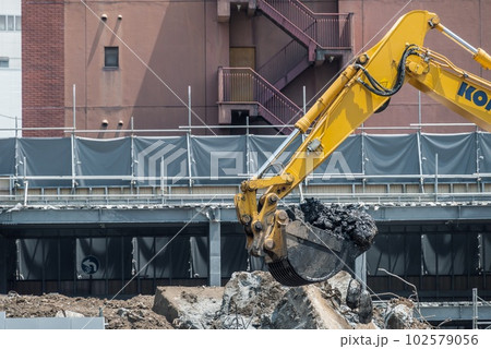 解体現場でガラ出しをする重機 102579056