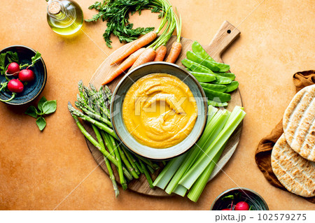 Chickpea hummus served with spring vegetables 102579275