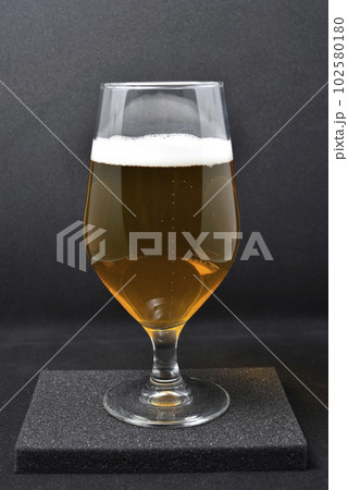 A glass of light beer on a black background. Fresh beer from a glass. 102580180