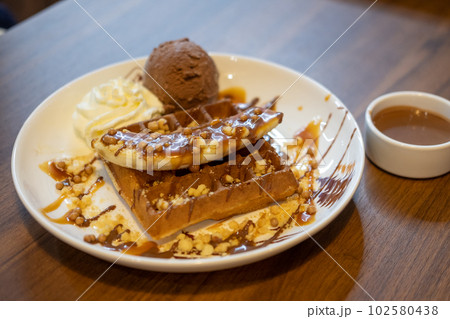 Chocolate waffle with ice cream served on plate Chocolate waffle with ice cream served on plate 102580438