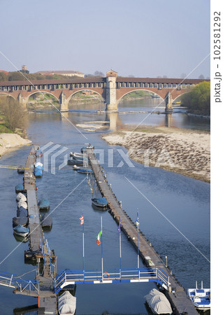 Nice view of covered bridge over the Ticino river in Pavia at sunny day Nice view of covered bridge over the Ticino river in Pavia at sunny day 102581292