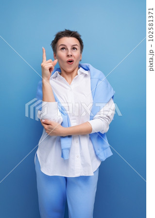 young well-groomed brilliant smart lady points her finger to the side pretending to have insight 102581371