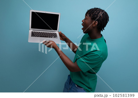 positive american man showing laptop screen on studio background with mockup and copy space 102581399