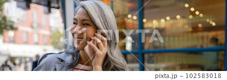 Busy mature lady taking stroll through city Busy mature lady taking stroll through city 102583018