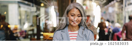 Happy mature lady working at city cafe Happy mature lady working at city cafe 102583035