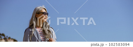 Happy mature woman smiling while standing outdoors 102583094