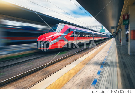 Red high speed train in motion on the railway station 102585349