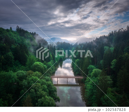 Aerial view of wooden bridge over the river in mountains at dawn 102587828