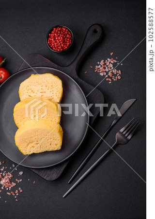 Delicious porous yellow cheese cut in large pieces on a ceramic plate Delicious porous yellow cheese cut in large pieces on a ceramic plate 102588577