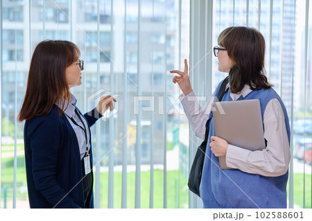 Meeting, conversation of female teacher and girl college student in educational center Meeting, conversation of female teacher and girl college student in educational center 102588601