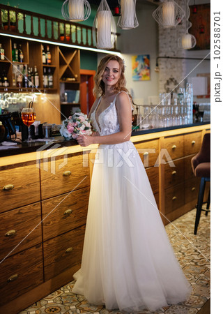 blonde bride in a bar near with a wedding bouquet 102588701