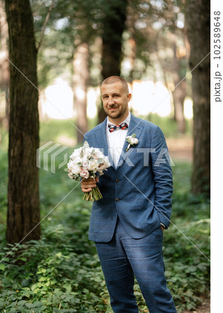 portrait of an elegant groom in a blue suit 102589648