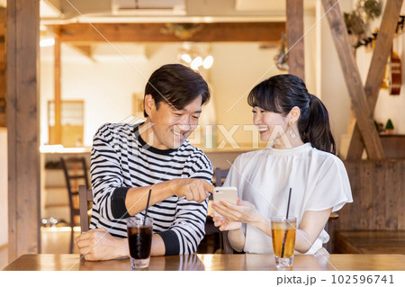 カフェ・喫茶店でスマホを使うアジア人のカップル・夫婦 カフェ・喫茶店でスマホを使うアジア人のカップル・夫婦 102596741