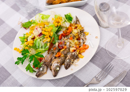 Fried blue whiting fish served with salad 102597029