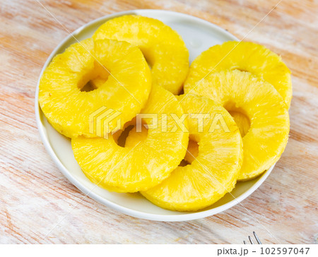 Ripe sliced pineapple on plate 102597047