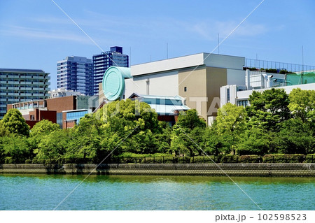 大川沿い桜之宮公園から見た青葉の桜の樹々の囲まれた造幣局本局　大阪市北区 102598523