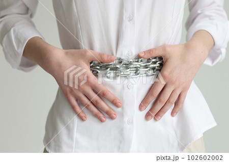 Woman with chain belt suffers from heaviness in stomach Woman with chain belt suffers from heaviness in stomach 102602002