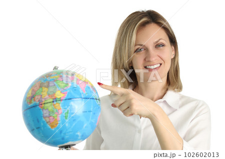 Positive blonde woman points to Earth globe in light studio 102602013