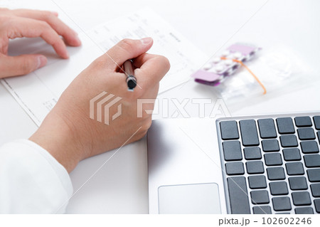 処方箋を確認する薬剤師の手。薬と診療報酬、レセコンイメージ 処方箋を確認する薬剤師の手。薬と診療報酬、レセコンイメージ 102602246