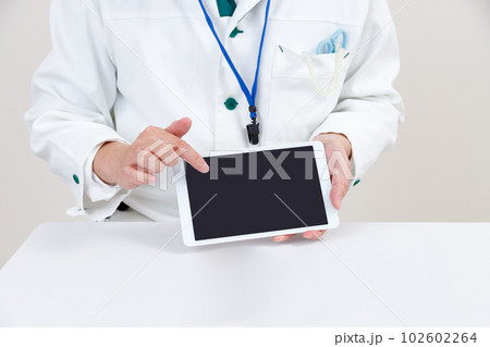 タブレット端末を持つ薬剤師、医療従事者。操作、説明をする 102602264