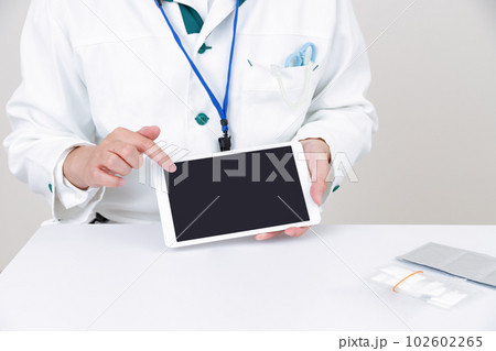 タブレット端末を持つ薬剤師、医療従事者。操作、説明をする 102602265