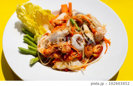 Spicy papaya salad with seafood 102603852