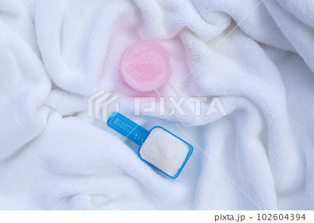 Detergent powder and fabric softener in measuring spoon on towel. Laundry concept. Detergent powder and fabric softener in measuring spoon on towel. Laundry concept. 102604394