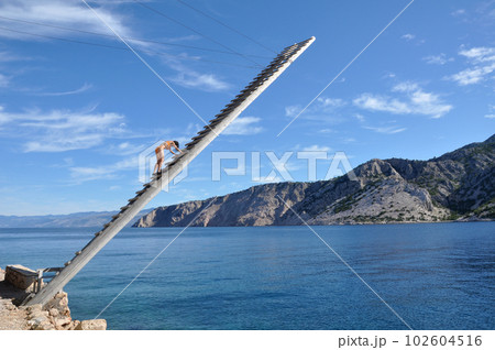 Lifeguard on a wooden ladder above the sea Lifeguard on a wooden ladder above the sea 102604516