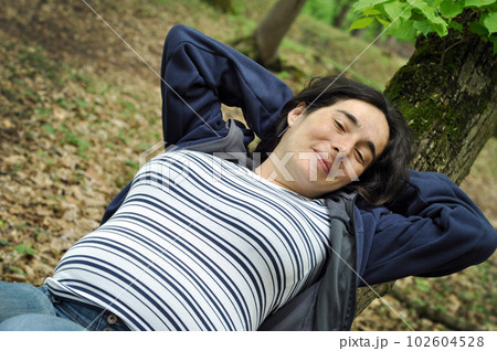Calm pregnant woman relaxing in the forest Calm pregnant woman relaxing in the forest 102604528