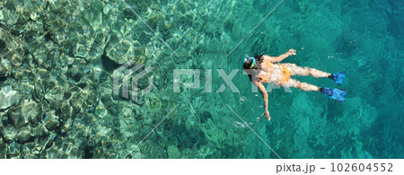 Young woman snorkeling in transparent shallow sea Young woman snorkeling in transparent shallow sea 102604552