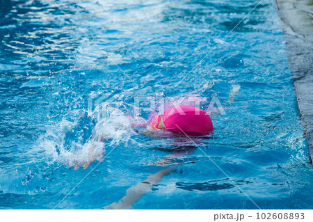 Little girl practicing swimming in the pool. Happy children swimming and playing in the water. summer vacation concept. 102608893