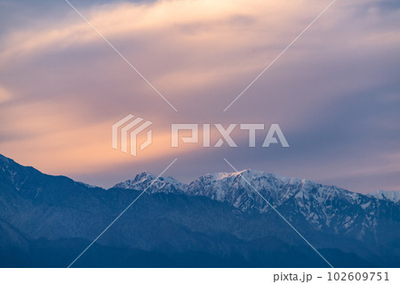 《長野県》北アルプスの山並みと松本市の街並み・夕暮れ 102609751
