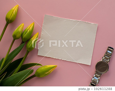 Womens wristwatch on pink background with tulip flowers and copy space 102611288