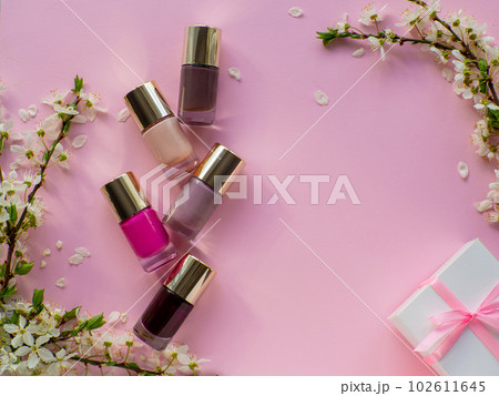 Set of cosmetic nail polishes with a gift box on pink background Set of cosmetic nail polishes with a gift box on pink background 102611645