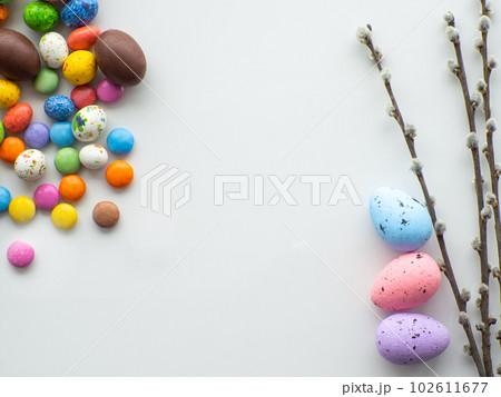Colorful and chocolate easter eggs with sweet dragee on white background 102611677